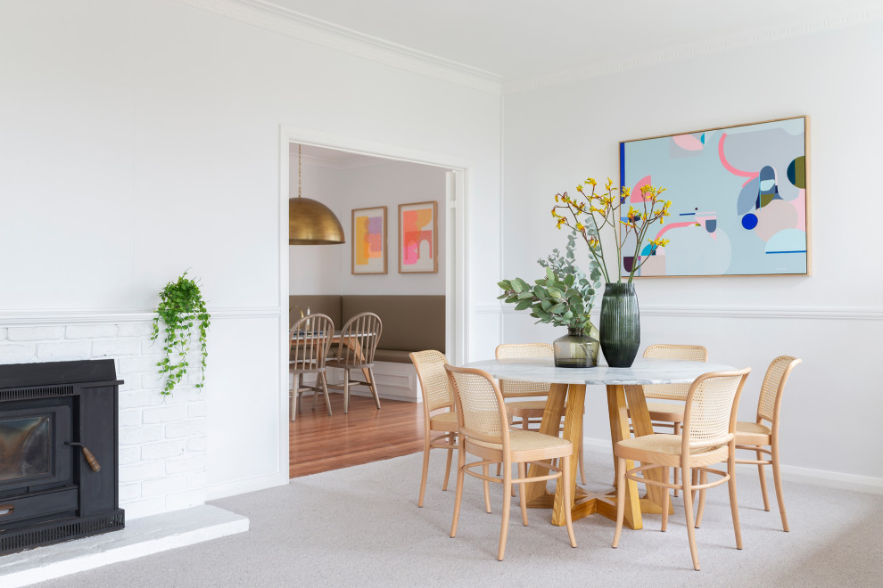 Inspiration pour une salle à manger traditionnelle avec moquette, un sol gris, un mur blanc et une cheminée standard.