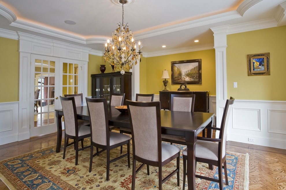 Classic dining room in Boston with yellow walls and medium hardwood flooring.