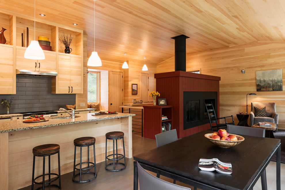 Aménagement d'une petite salle à manger ouverte sur le salon montagne avec une cheminée standard, un manteau de cheminée en bois, un mur beige, un sol en bois brun, un sol marron et éclairage.
