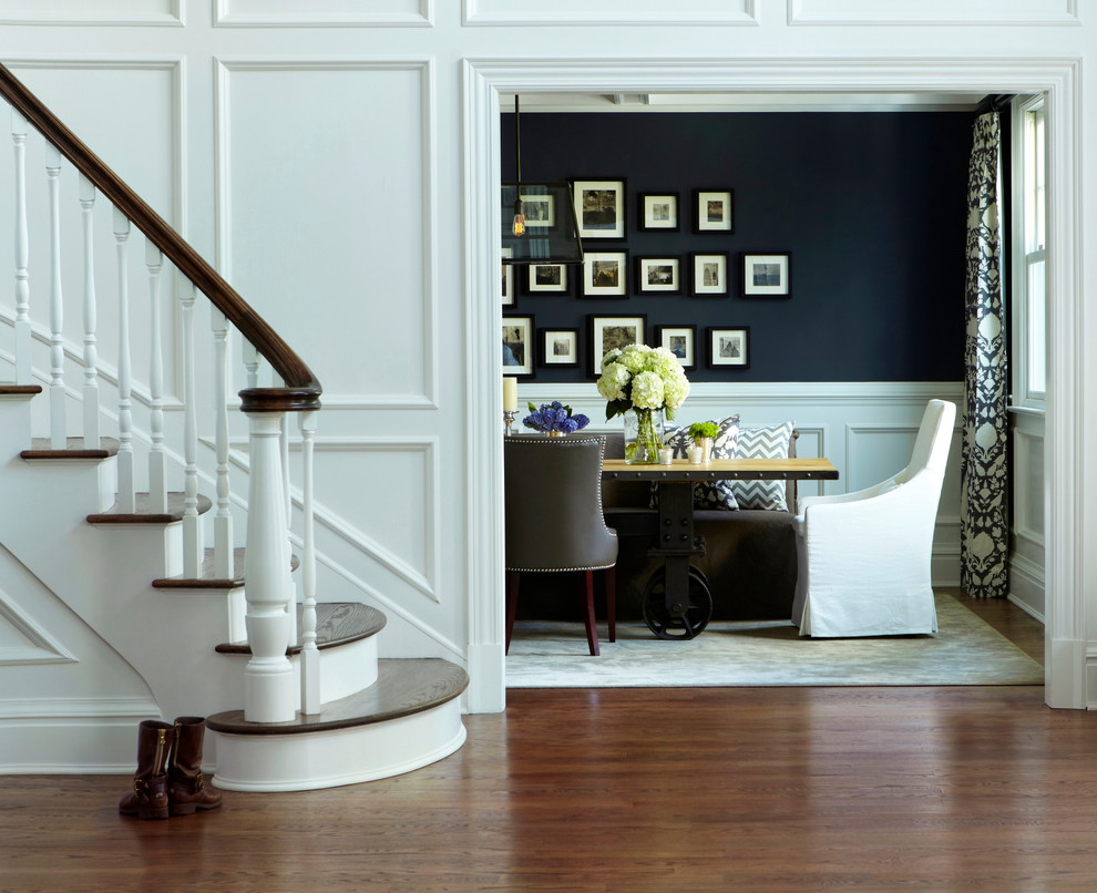 Example of a huge classic medium tone wood floor enclosed dining room design in New York with black walls and no fireplace