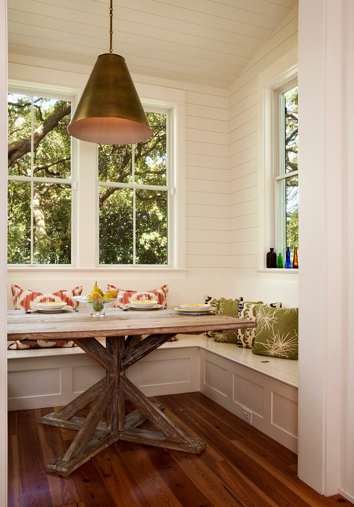 Nautical kitchen/dining room in Charleston with white walls and dark hardwood flooring.