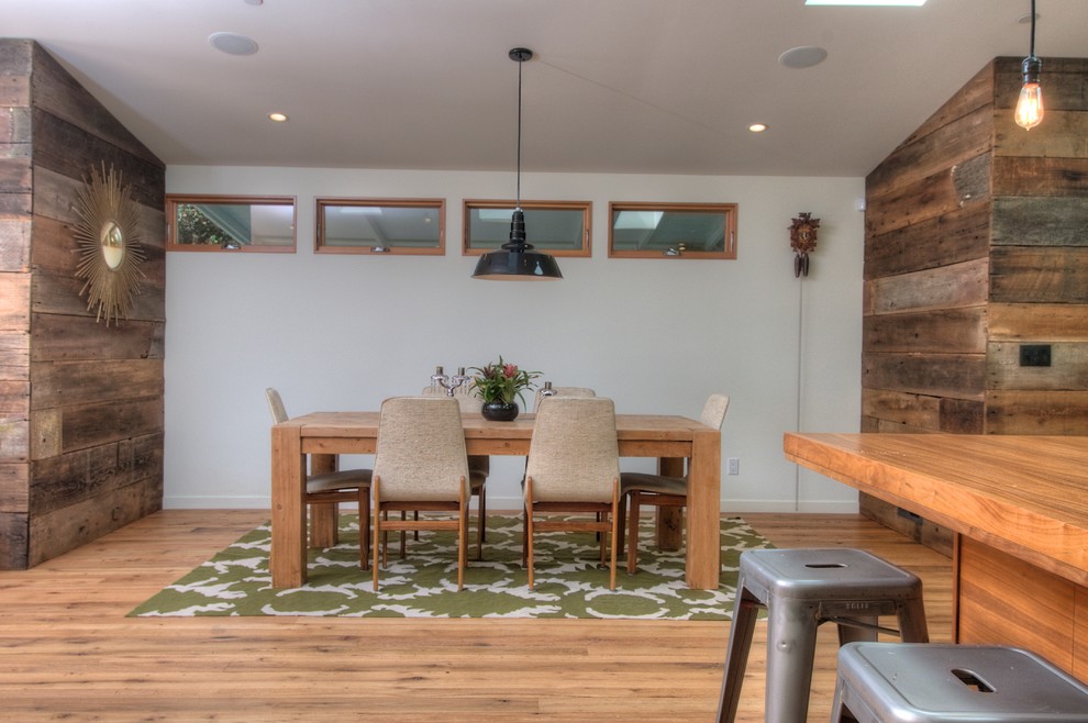 Idée de décoration pour une salle à manger vintage avec un mur blanc et un sol en bois brun.