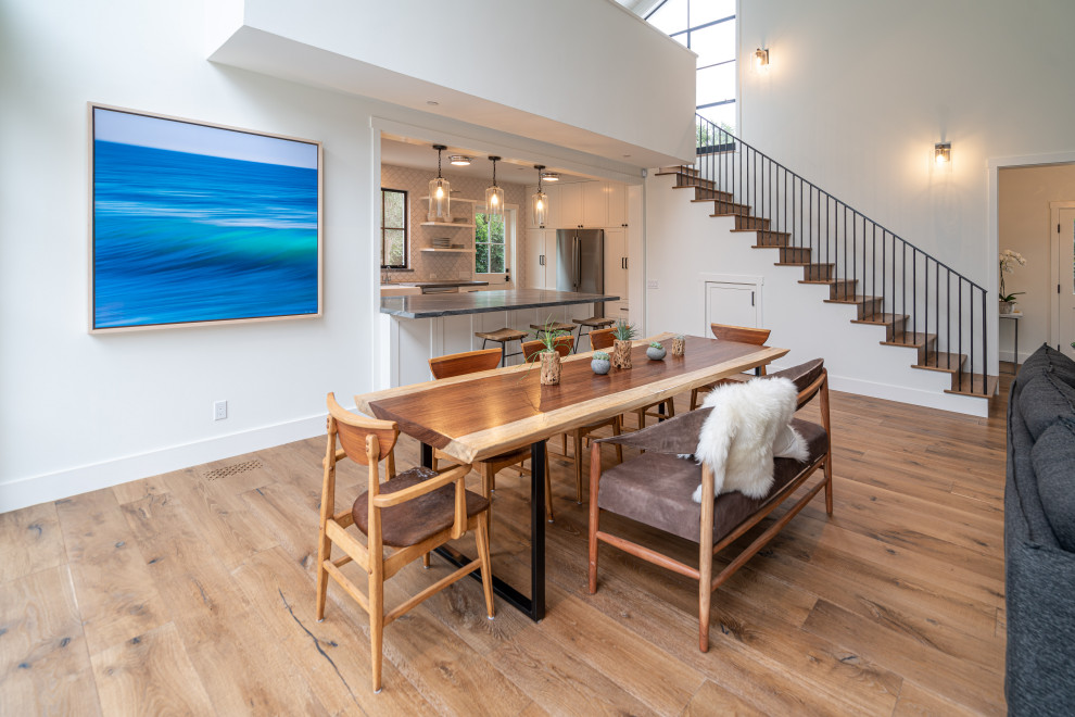 Photo of a medium sized modern open plan dining room in Santa Barbara with white walls, medium hardwood flooring, a standard fireplace, a plastered fireplace surround, brown floors and a timber clad ceiling.