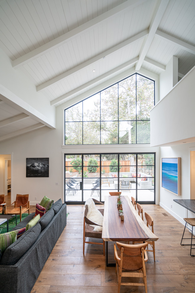 Esempio di una sala da pranzo aperta verso il soggiorno moderna di medie dimensioni con pareti bianche, pavimento in legno massello medio, pavimento marrone e soffitto in perlinato