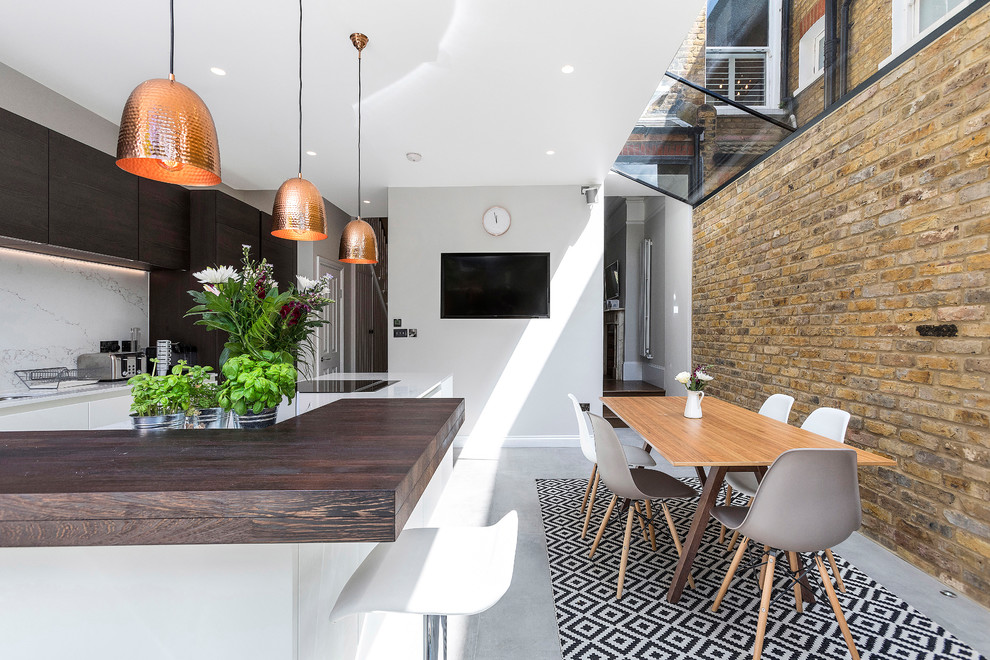 Esempio di una sala da pranzo aperta verso la cucina contemporanea di medie dimensioni con pavimento in cemento e pavimento grigio