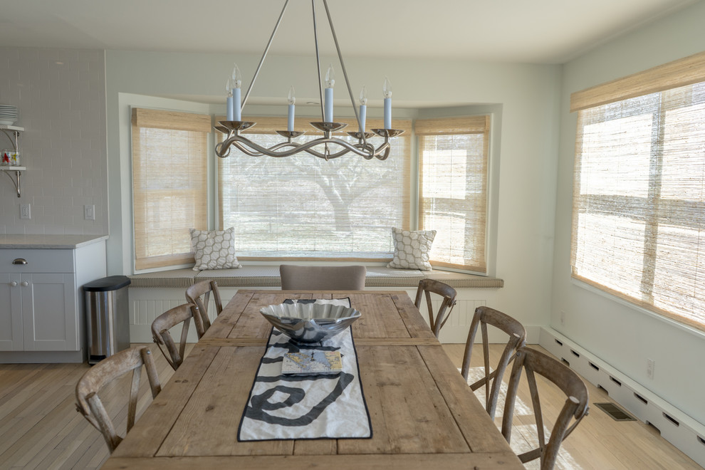 Inspiration pour une salle à manger ouverte sur la cuisine marine de taille moyenne avec parquet clair, aucune cheminée, un mur blanc et un sol beige.