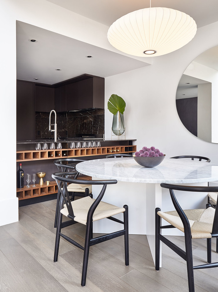 Moderne Wohnküche mit weißer Wandfarbe, braunem Holzboden und braunem Boden in New York