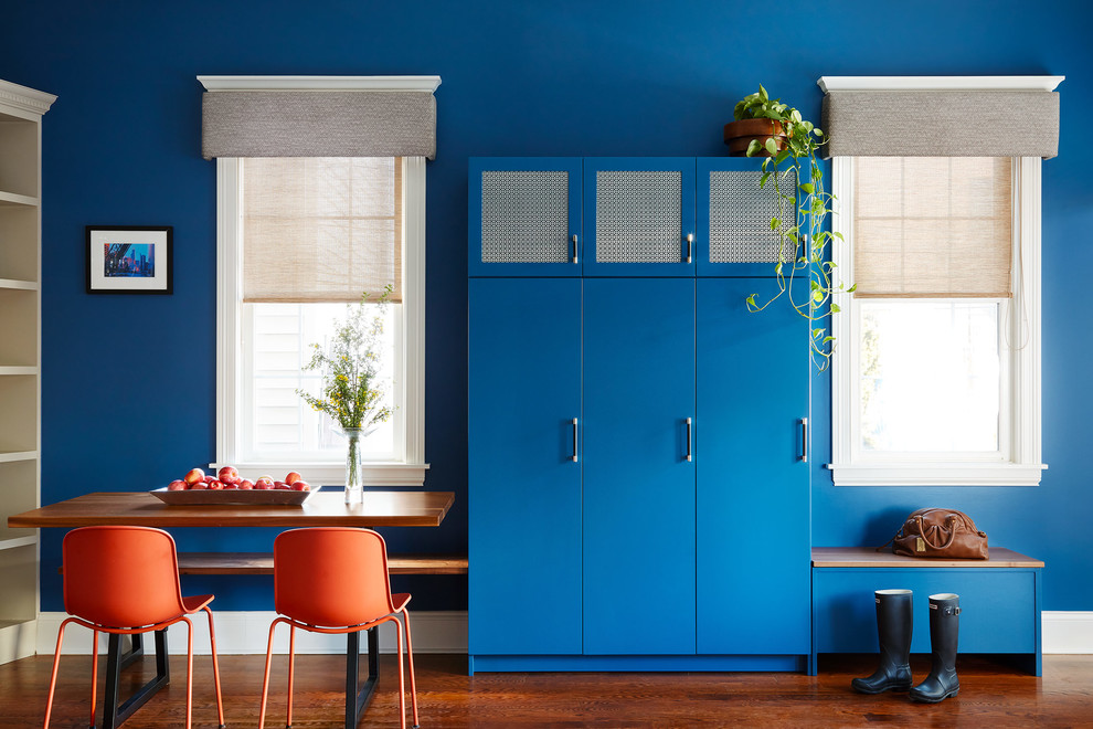 Foto di una sala da pranzo aperta verso il soggiorno boho chic con pareti blu, pavimento in legno massello medio e pavimento marrone
