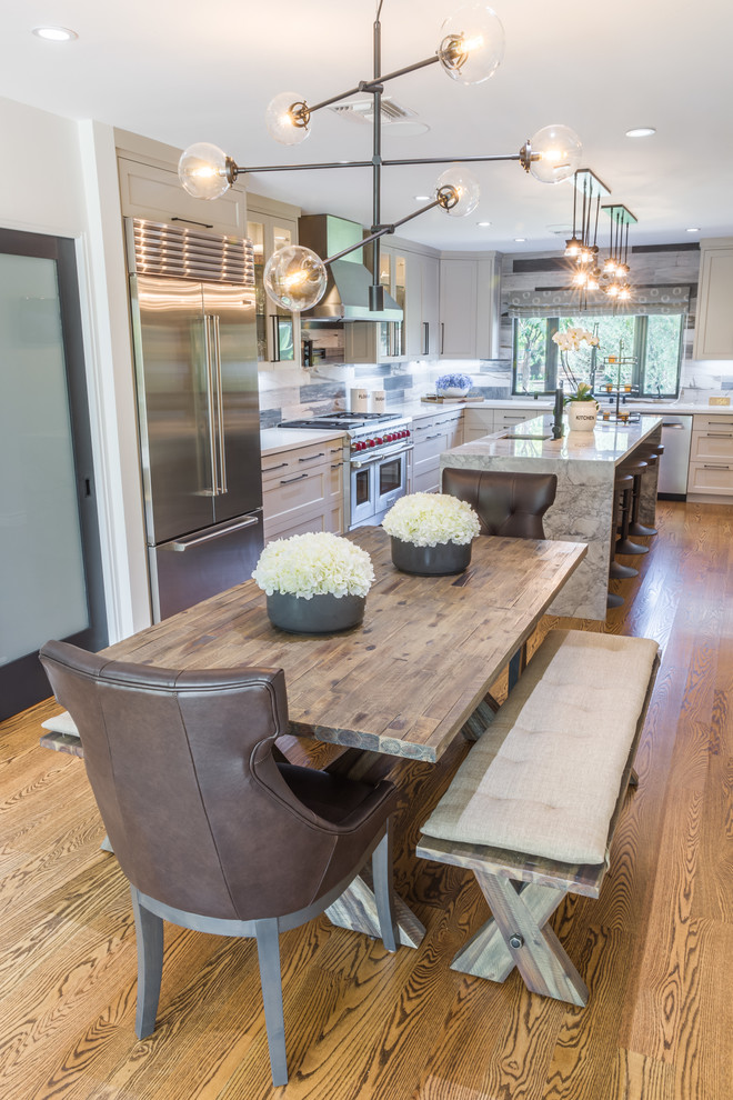 Cette photo montre une salle à manger ouverte sur la cuisine nature de taille moyenne avec un mur gris et un sol en bois brun.