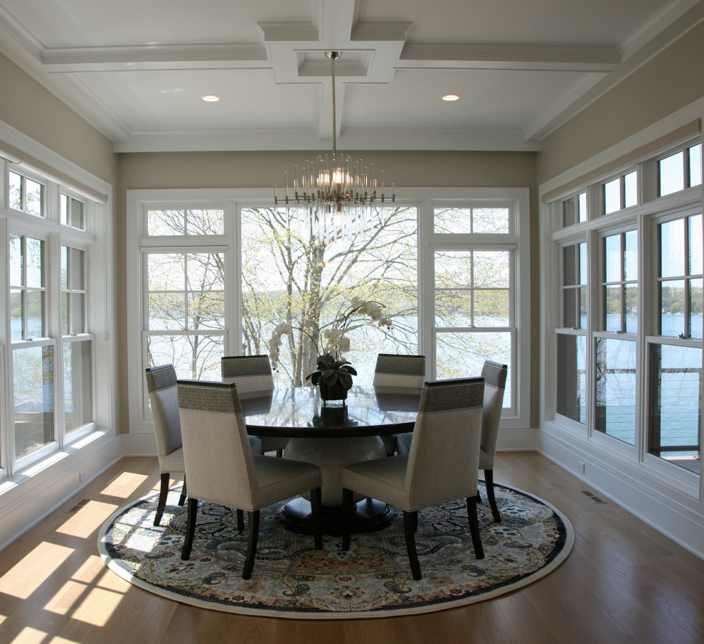 Immagine di una sala da pranzo aperta verso la cucina chic di medie dimensioni con pareti beige, parquet chiaro, pavimento marrone e soffitto a cassettoni