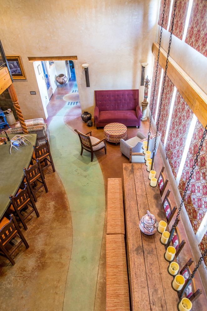 Foto di una sala da pranzo aperta verso la cucina stile americano di medie dimensioni con pareti beige, pavimento in cemento, stufa a legna, cornice del camino in cemento e pavimento verde