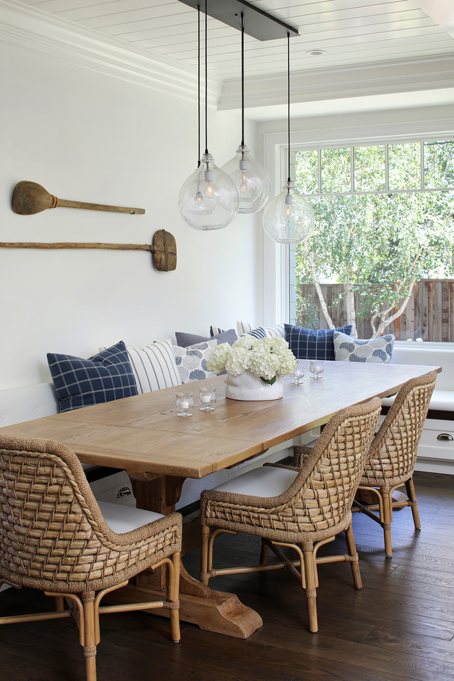 Photo of a beach style dining room in San Francisco with white walls, dark hardwood flooring and brown floors.