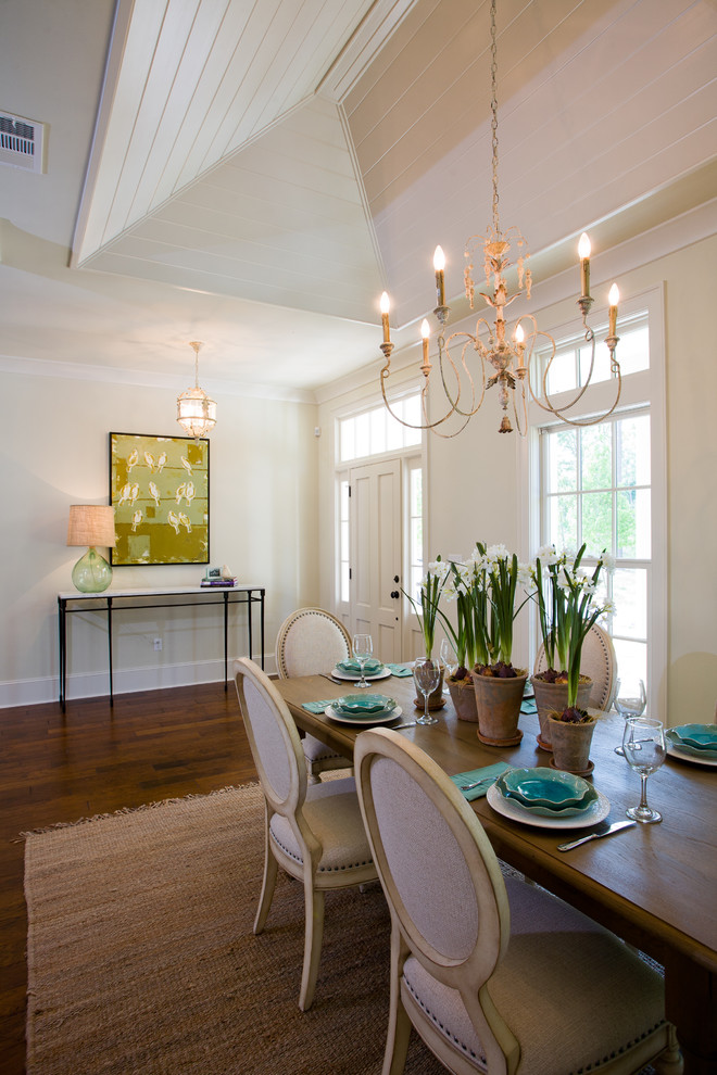 Cette image montre une salle à manger ouverte sur le salon traditionnelle de taille moyenne avec un mur beige, parquet foncé et éclairage.