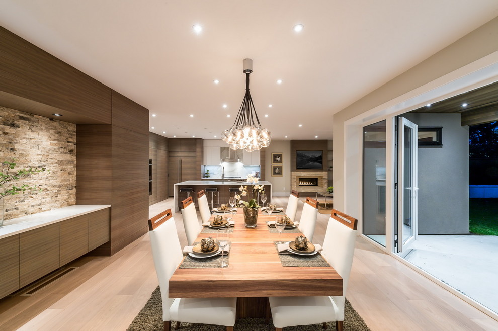 Large trendy light wood floor great room photo in Vancouver with white walls and a standard fireplace