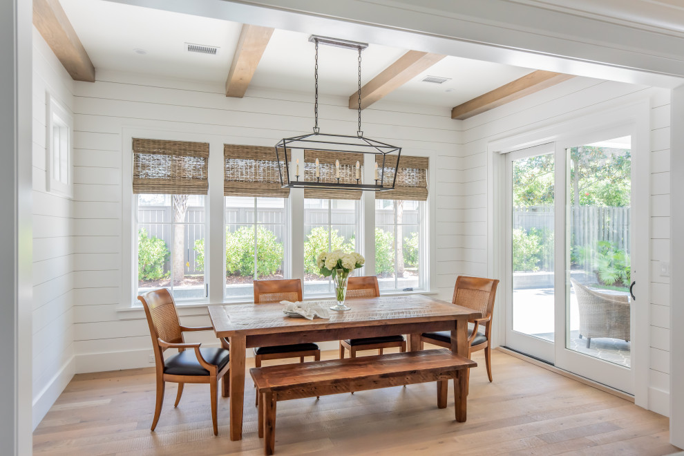 Inspiration for a beach style kitchen/dining room with white walls, light hardwood flooring, exposed beams and tongue and groove walls.