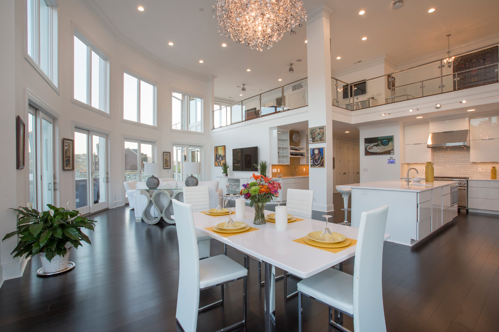 Immagine di una grande sala da pranzo aperta verso la cucina minimal con pareti bianche e pavimento in bambù