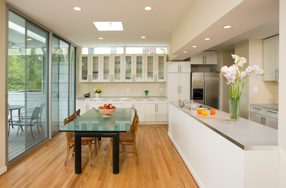 Ispirazione per una sala da pranzo aperta verso la cucina design di medie dimensioni con pareti beige e pavimento in legno massello medio