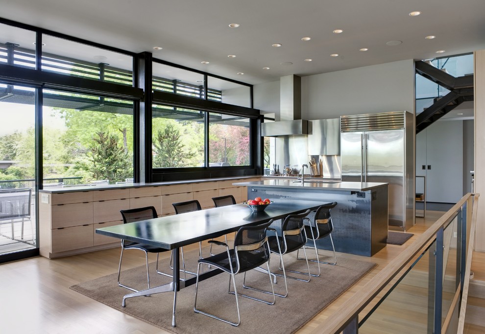 Ispirazione per una sala da pranzo aperta verso la cucina minimal di medie dimensioni con pareti grigie, parquet chiaro e nessun camino