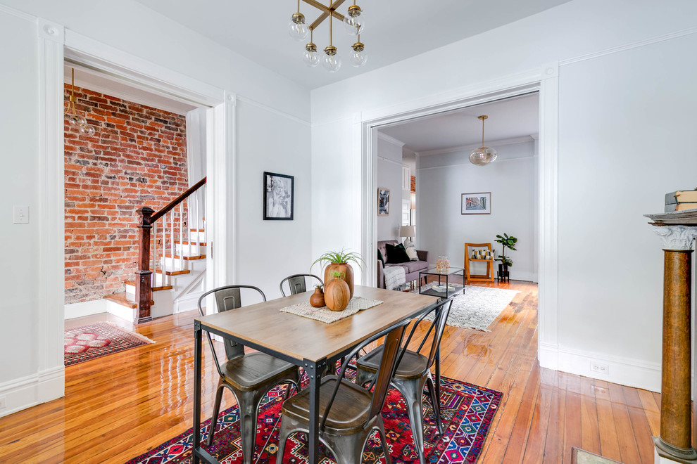 This is an example of a small classic enclosed dining room in Wilmington with grey walls, medium hardwood flooring, a standard fireplace and brown floors.