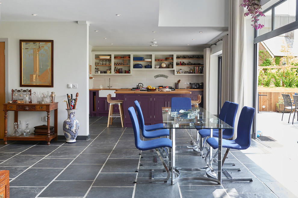 Large contemporary open plan dining room in Wiltshire with white walls, slate flooring and black floors.