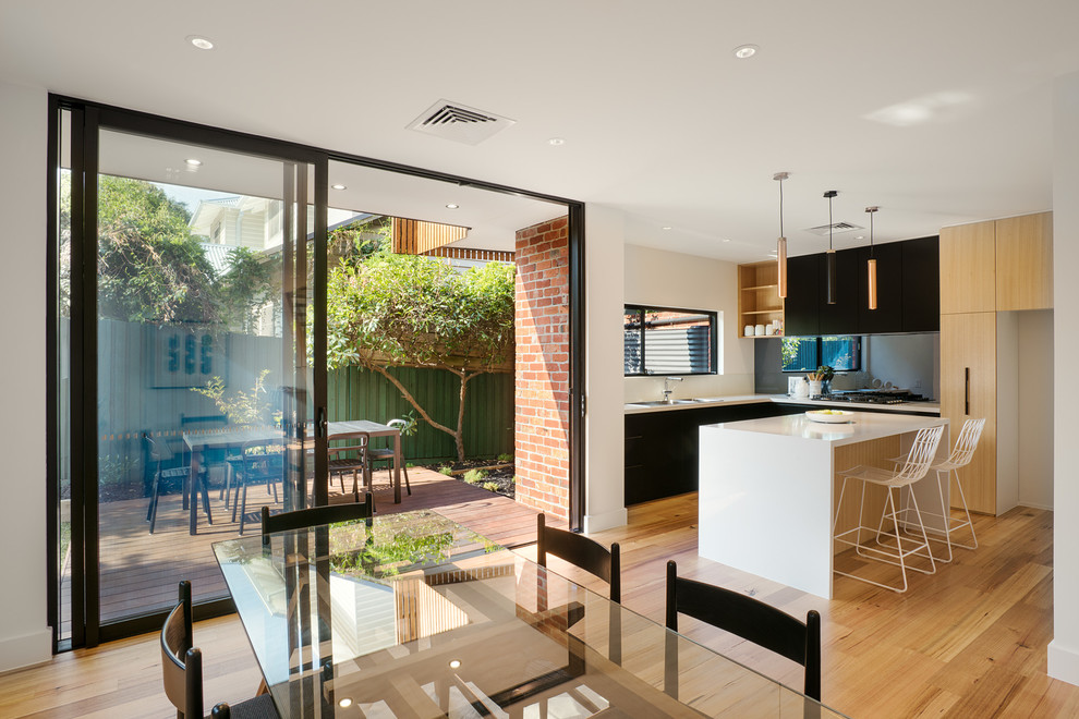 Medium sized contemporary kitchen/dining room in Melbourne with white walls, light hardwood flooring and no fireplace.