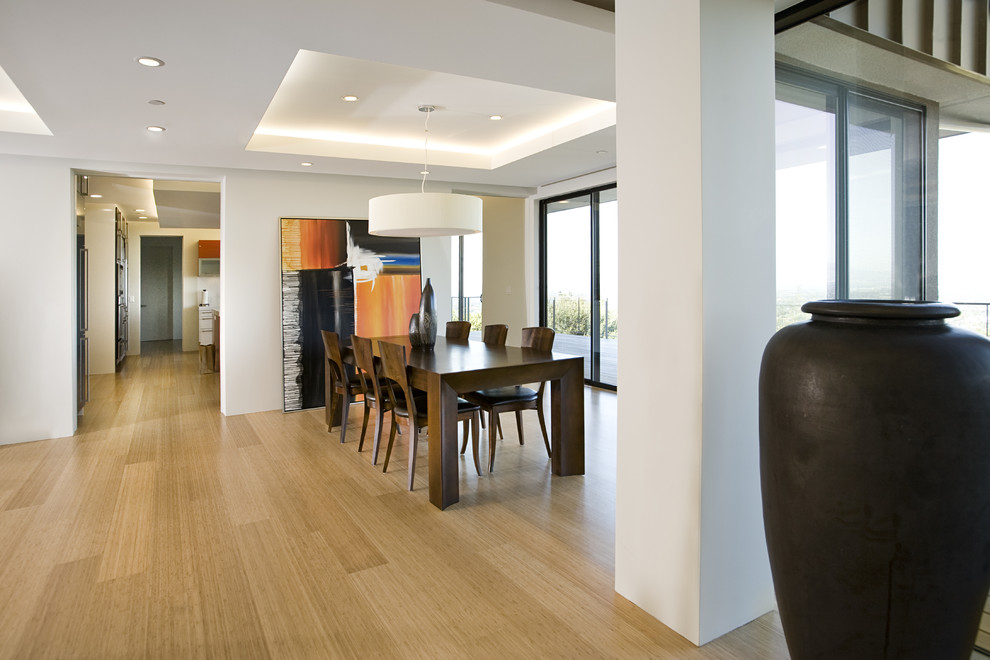 This is an example of a medium sized contemporary kitchen/dining room in San Francisco with bamboo flooring and white walls.