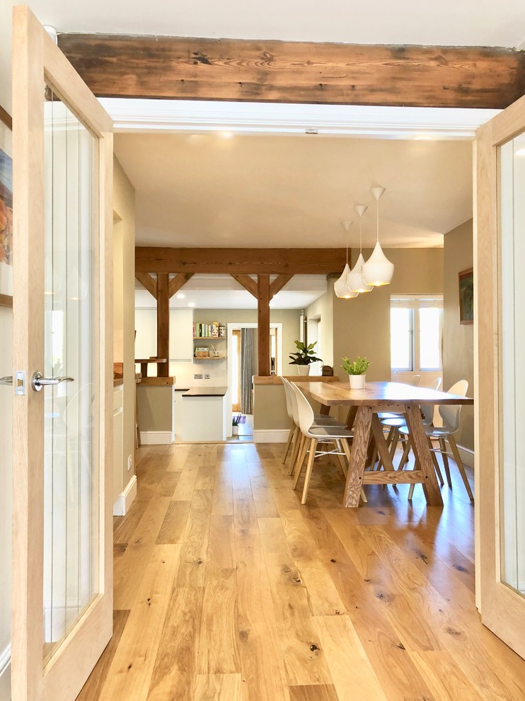 Imagen de comedor de cocina actual de tamaño medio con paredes beige, suelo de madera clara y suelo beige