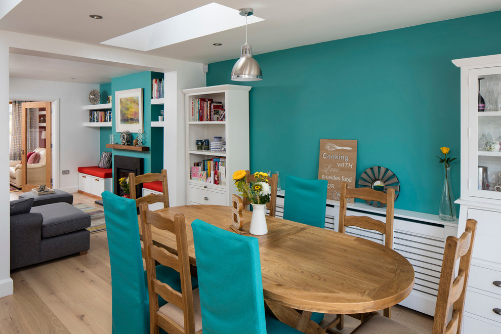 This is an example of a medium sized beach style open plan dining room in Dublin with blue walls and light hardwood flooring.
