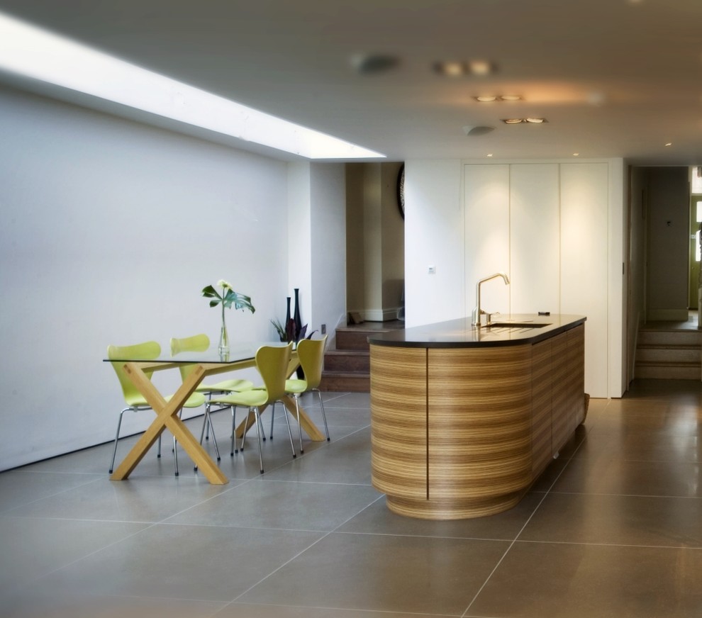 Esempio di una sala da pranzo aperta verso la cucina design di medie dimensioni con pareti bianche, parquet chiaro e nessun camino