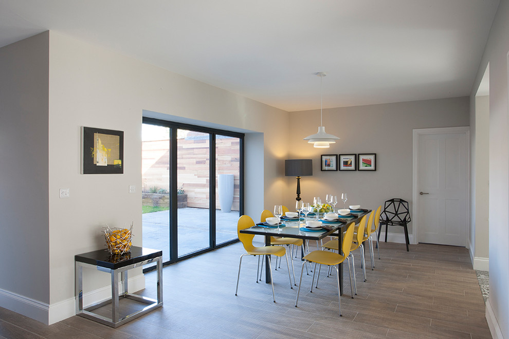 Photo of a retro enclosed dining room in West Midlands with grey walls and medium hardwood flooring.