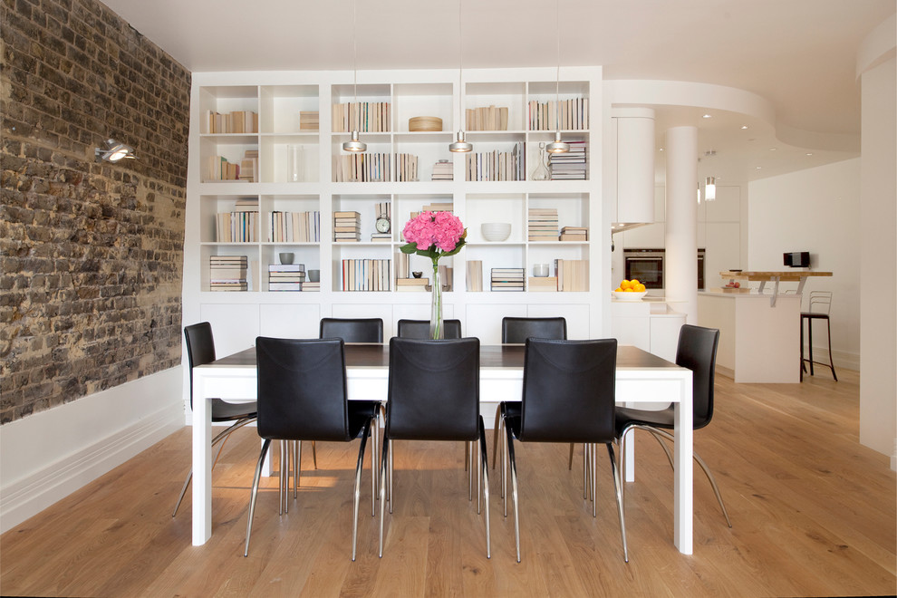 Cette photo montre une salle à manger ouverte sur la cuisine scandinave de taille moyenne avec un mur blanc et un sol en bois brun.