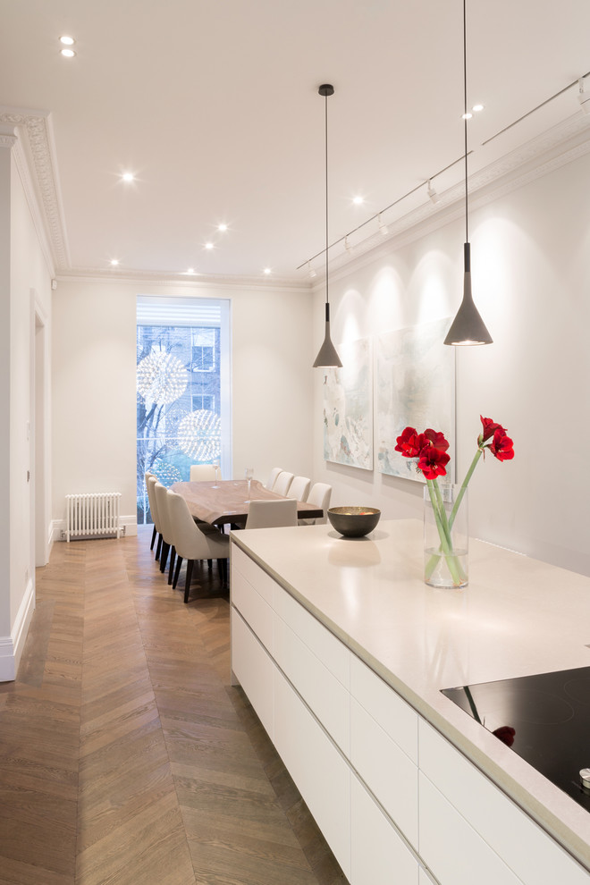 Источник вдохновения для домашнего уюта: кухня-столовая в современном стиле с белыми стенами и светлым паркетным полом без камина