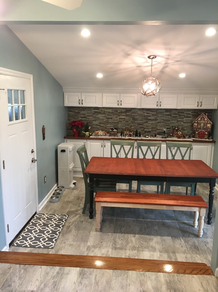 Example of a mid-sized farmhouse medium tone wood floor enclosed dining room design in Newark with blue walls and no fireplace