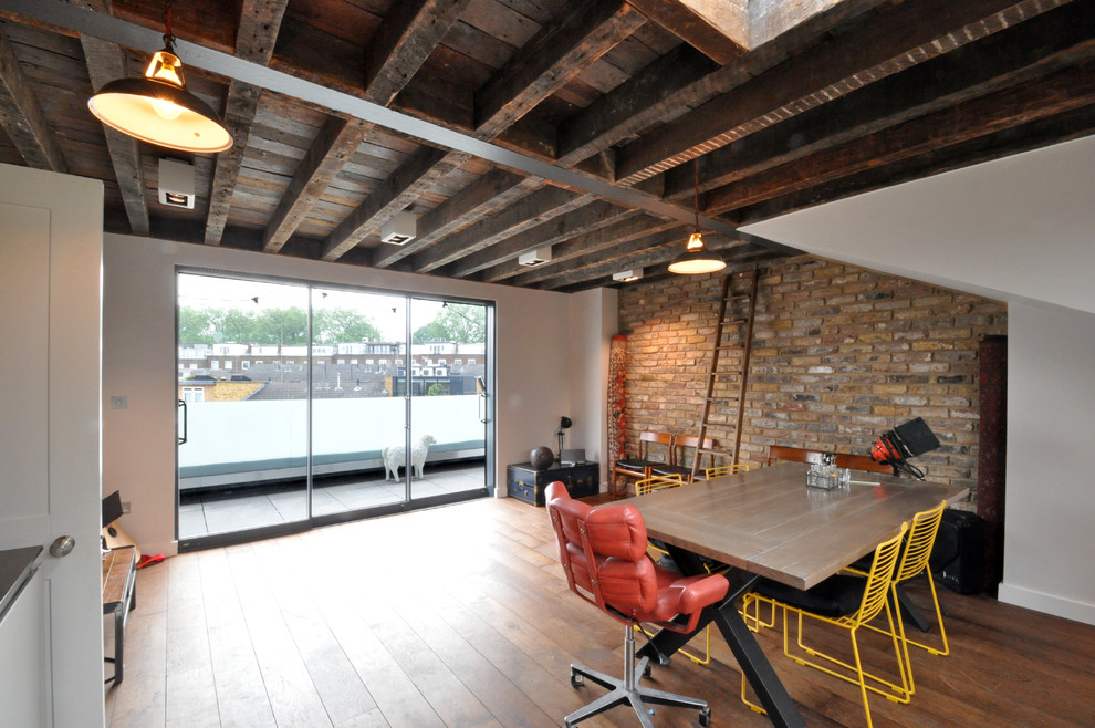 Exemple d'une salle à manger ouverte sur le salon industrielle de taille moyenne avec un mur blanc, un sol en bois brun et aucune cheminée.