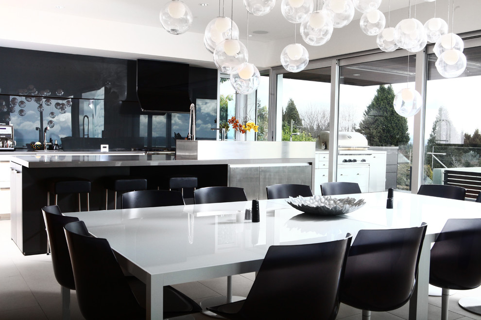 На фото: кухня-столовая среднего размера в современном стиле с белыми стенами и полом из известняка с