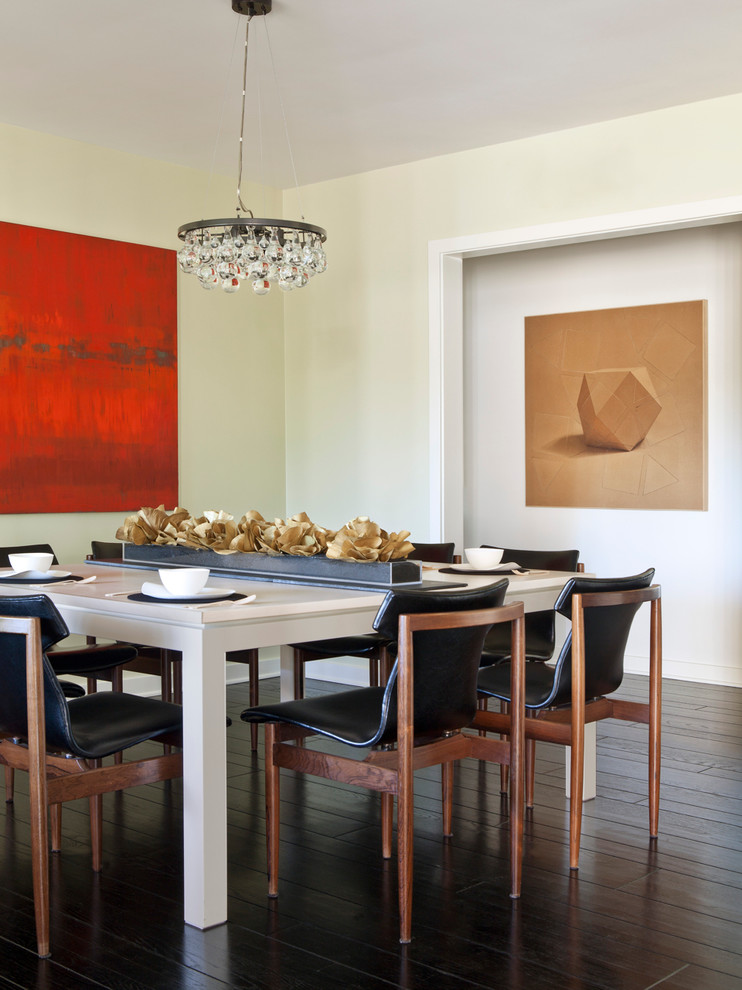 Aménagement d'une salle à manger contemporaine avec un mur beige et parquet foncé.