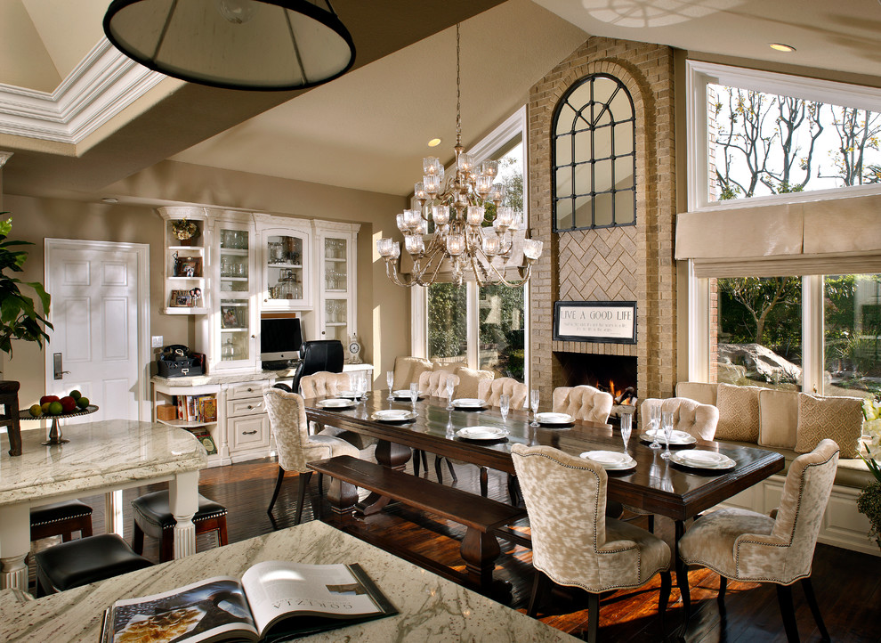 Inspiration for a large classic open plan dining room in Orange County with beige walls, dark hardwood flooring, a standard fireplace and a brick fireplace surround.