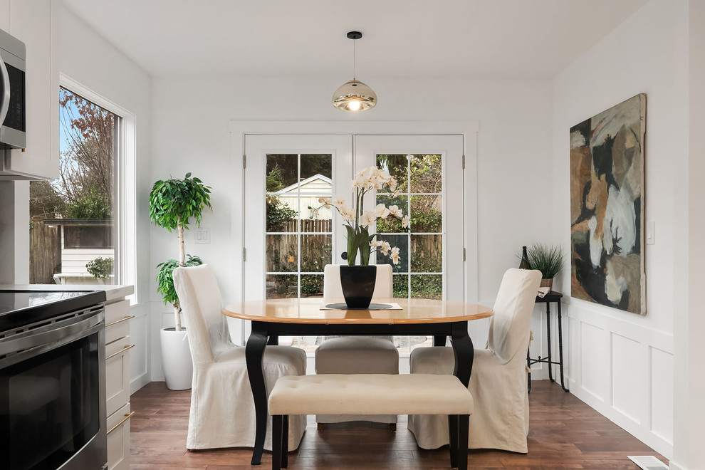 Idee per una sala da pranzo aperta verso la cucina country con pareti bianche, pavimento in legno massello medio e pavimento marrone