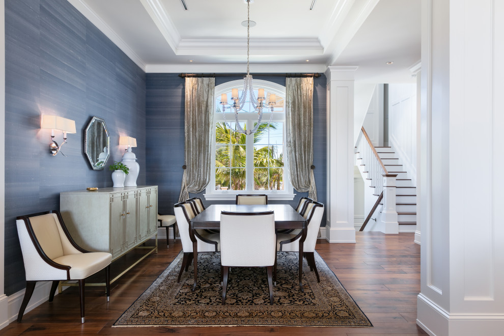 Immagine di una sala da pranzo aperta verso il soggiorno stile marinaro di medie dimensioni con pareti blu, parquet scuro, camino classico, cornice del camino in legno e pavimento marrone