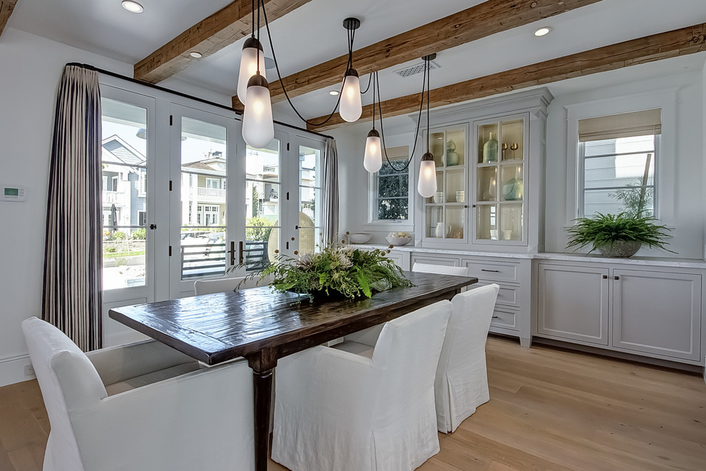 Inspiration for a coastal light wood floor dining room remodel in Orange County with white walls
