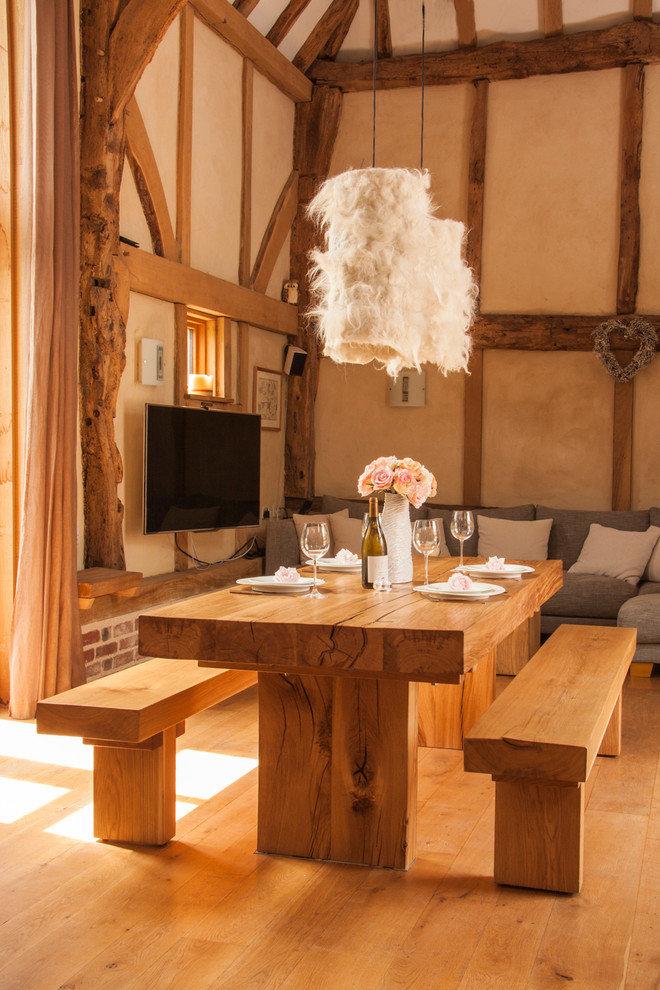 Idee per una grande sala da pranzo aperta verso il soggiorno stile rurale con pareti beige, pavimento in legno massello medio e nessun camino