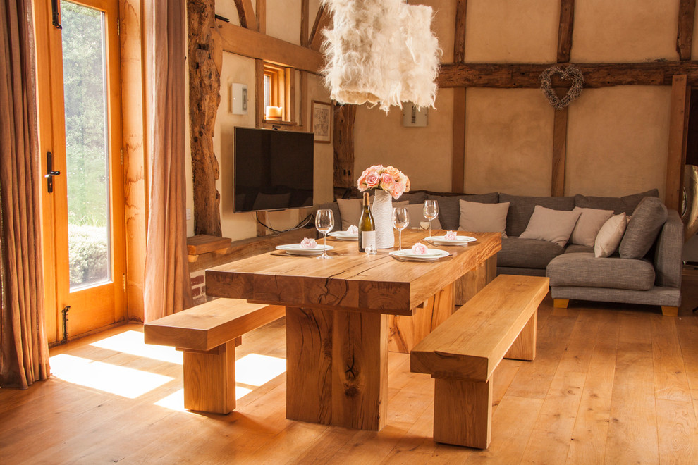 Great room - large rustic medium tone wood floor great room idea in Sussex with beige walls and no fireplace