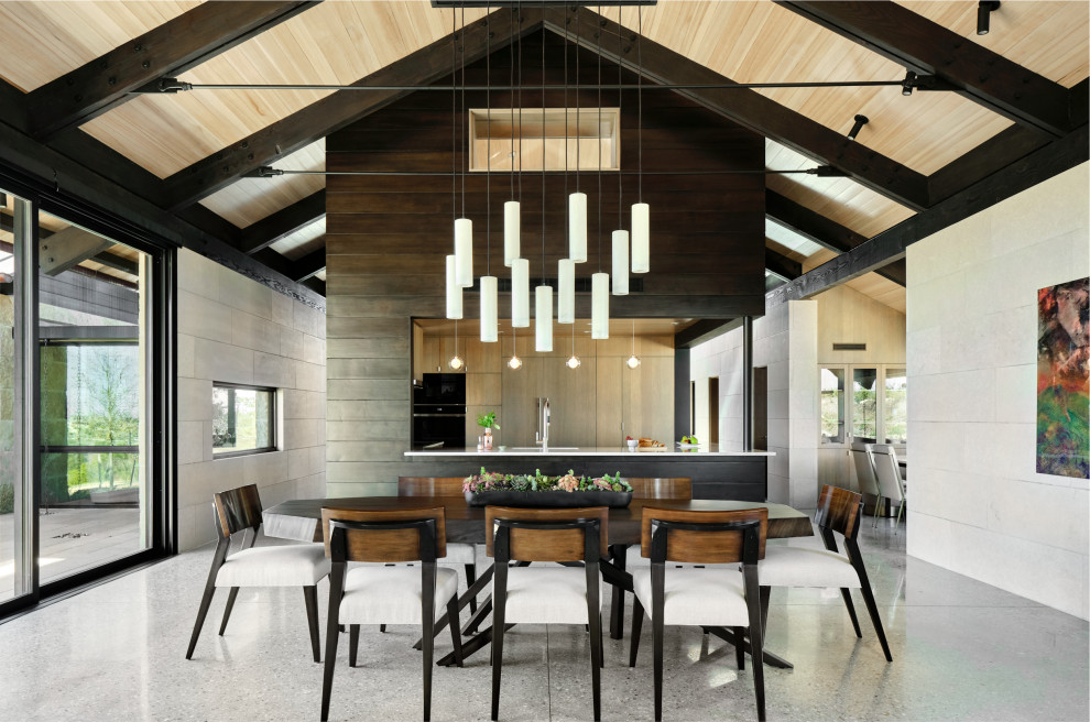 Cette photo montre une salle à manger ouverte sur la cuisine tendance de taille moyenne avec un mur beige, sol en béton ciré, un sol gris, un plafond en bois, poutres apparentes et un plafond voûté.
