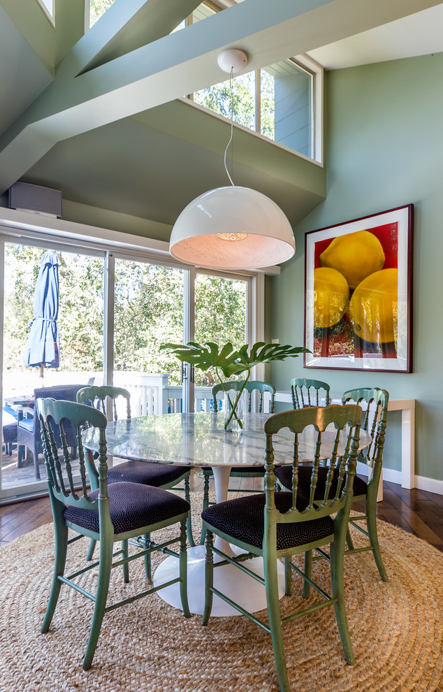 Immagine di una sala da pranzo boho chic con pareti verdi, parquet scuro e pavimento beige