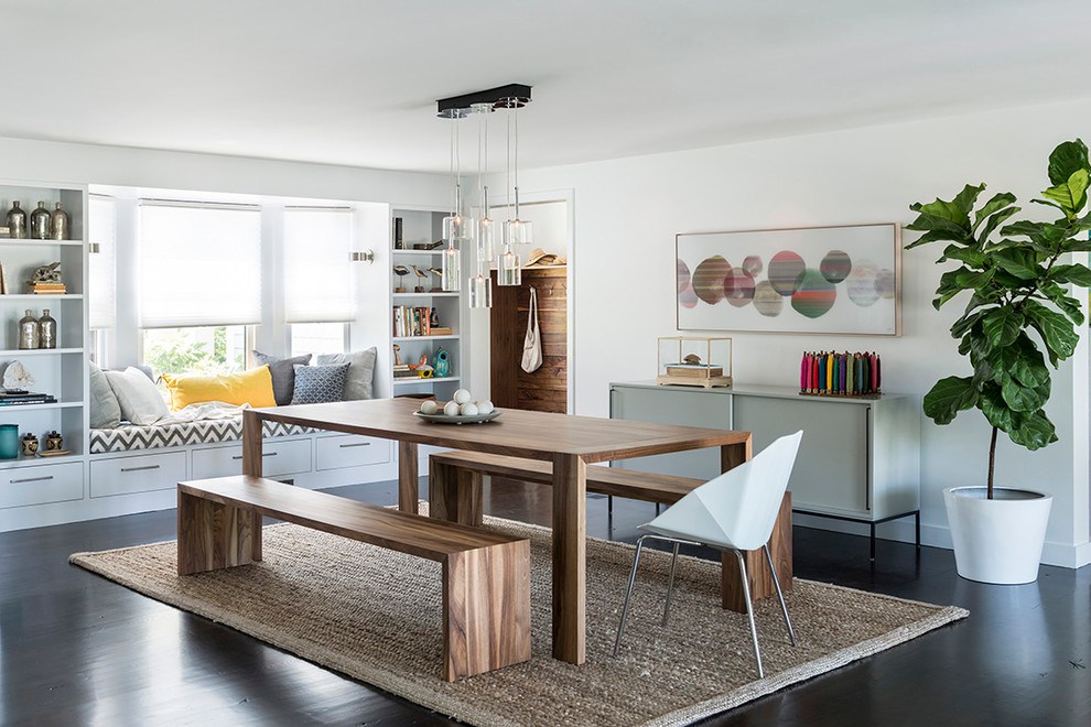 This is an example of a beach style dining room in Boston with white walls and dark hardwood flooring.