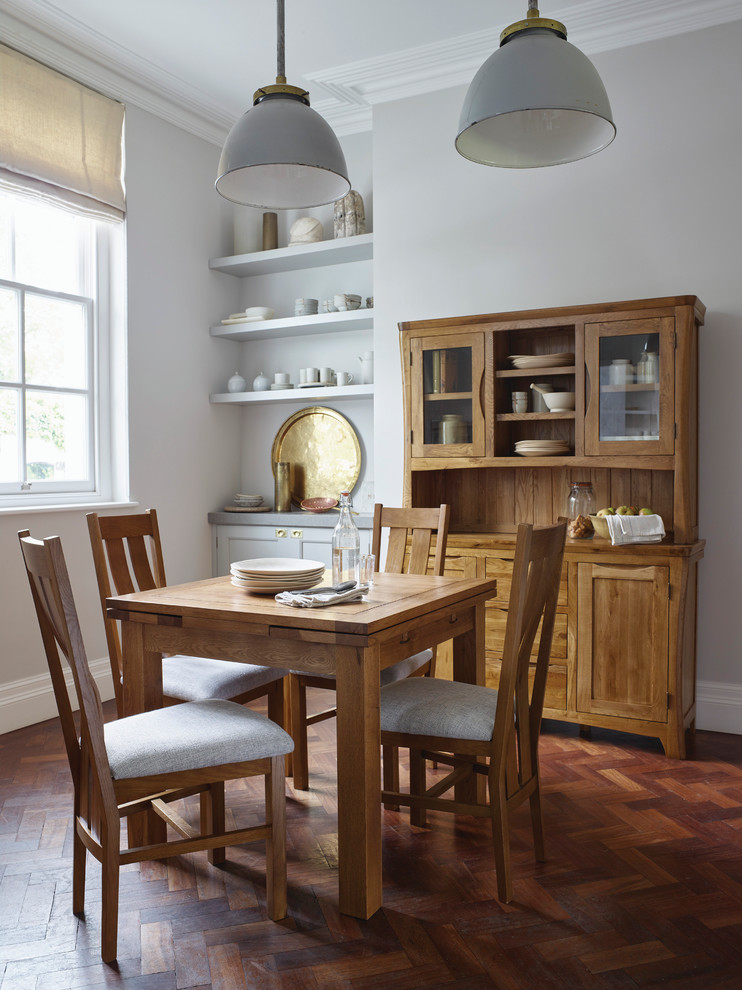 Modelo de comedor de estilo de casa de campo pequeño sin chimenea con paredes grises y suelo de madera oscura