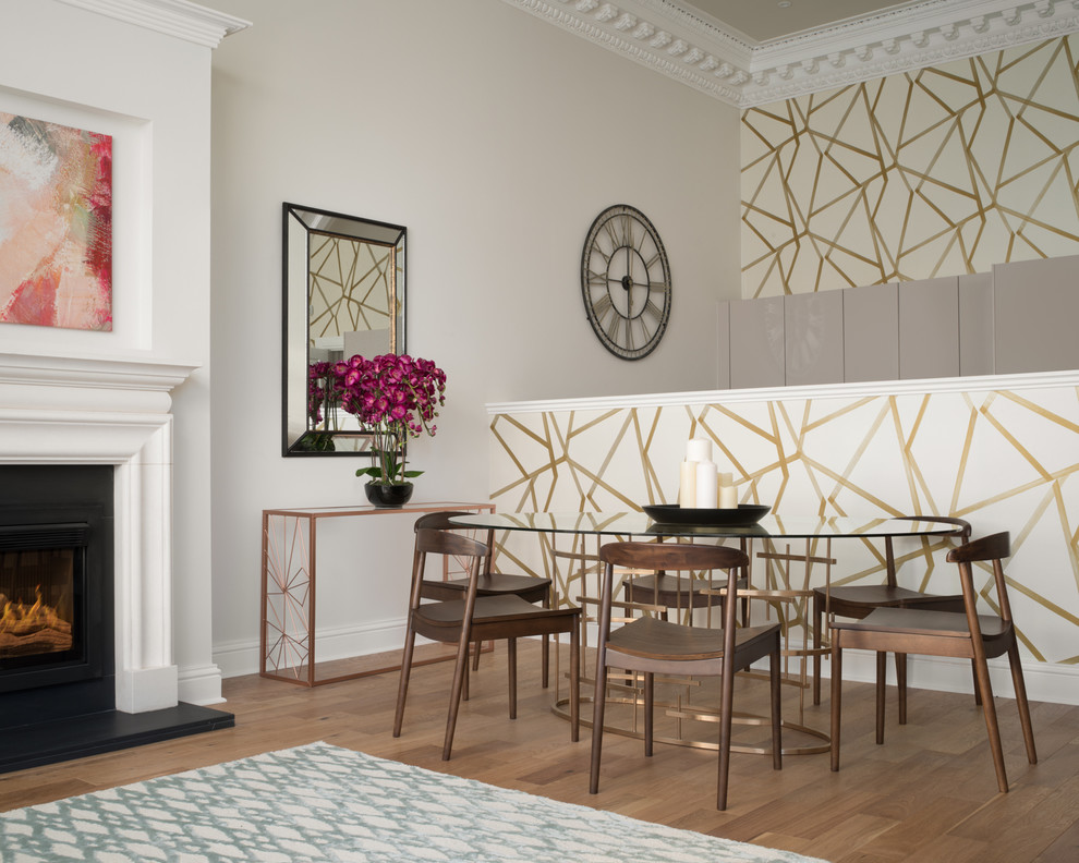 Idée de décoration pour une salle à manger tradition avec un mur gris, un sol en bois brun et une cheminée standard.
