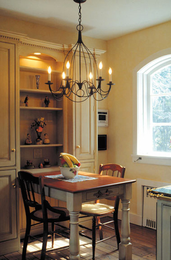 Example of a small island style medium tone wood floor kitchen/dining room combo design in Minneapolis with yellow walls