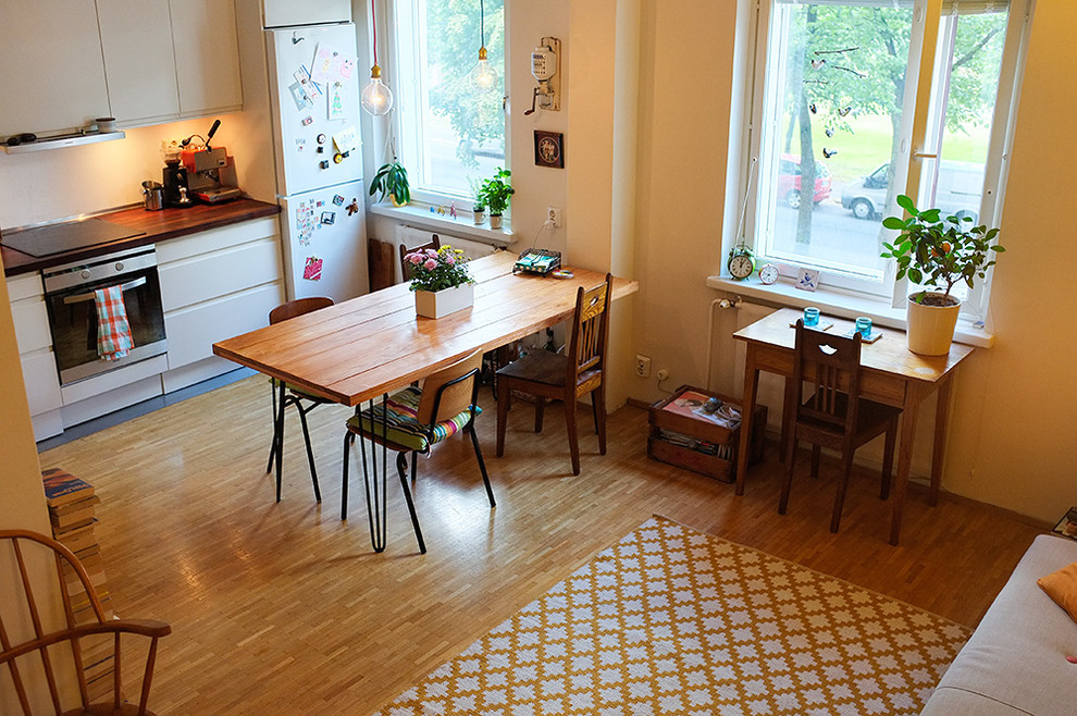 Idee per una sala da pranzo aperta verso il soggiorno boho chic con pareti bianche e pavimento in legno massello medio