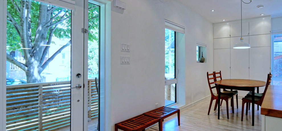 Cette image montre une petite salle à manger design avec un mur blanc et parquet clair.